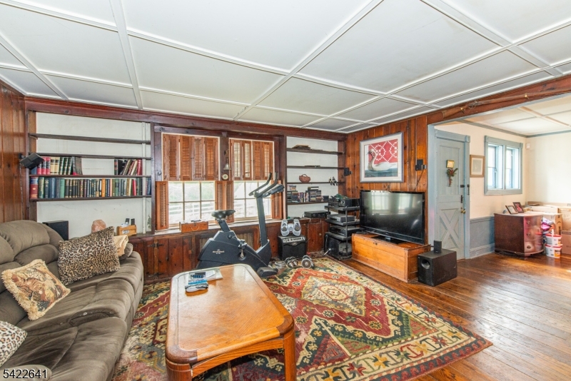 570 Mine Brook Road Bernardsville, NJ 07924 - Photo 9 of 38 a living room with furniture a flat screen tv and a floor to ceiling window