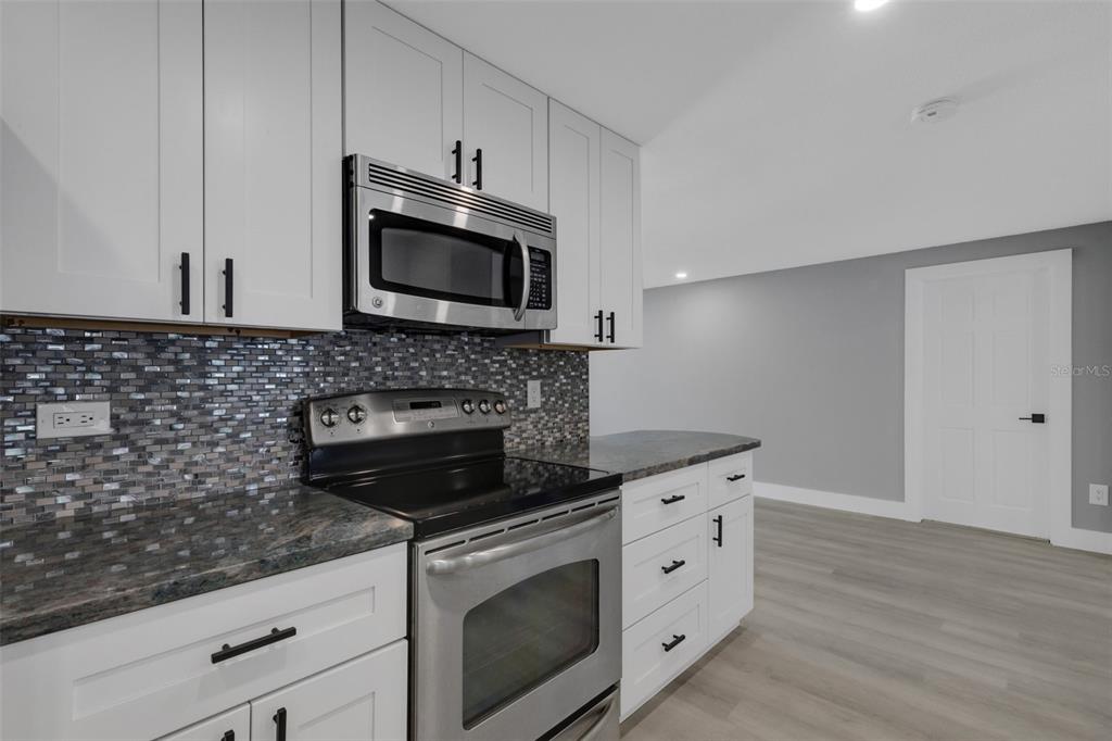 4645 Hunter Ridge Drive Sarasota, FL 34233 - Photo 24 of 70 a kitchen with granite countertop a stove microwave and sink