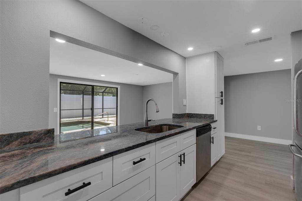 4645 Hunter Ridge Drive Sarasota, FL 34233 - Photo 26 of 70 a kitchen with granite countertop a stove and a sink