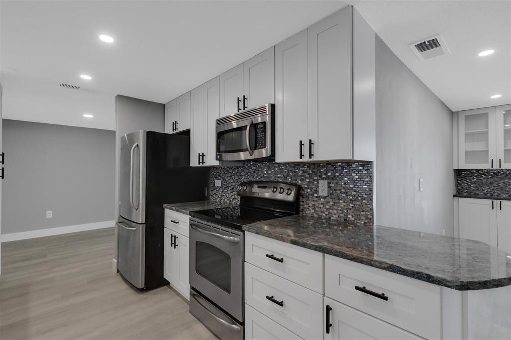 4645 Hunter Ridge Drive Sarasota, FL 34233 - Photo 27 of 70 a kitchen with granite countertop a refrigerator and a sink