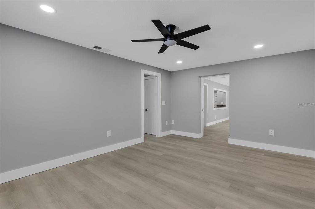 4645 Hunter Ridge Drive Sarasota, FL 34233 - Photo 42 of 70 an empty room with wooden floor and windows