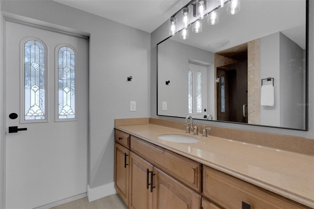 4645 Hunter Ridge Drive Sarasota, FL 34233 - Photo 44 of 70 a bathroom with a sink a large mirror and a vanity