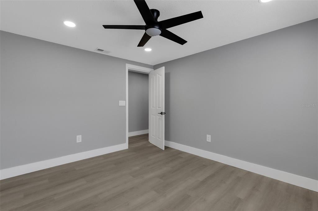 4645 Hunter Ridge Drive Sarasota, FL 34233 - Photo 49 of 70 an empty room with wooden floor and ceiling fan