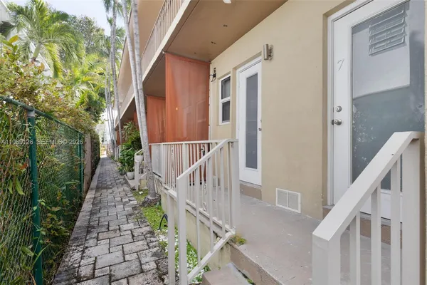 a view of a pathway of a house with wooden floor and fence
