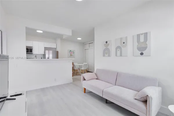 a living room with furniture and kitchen view
