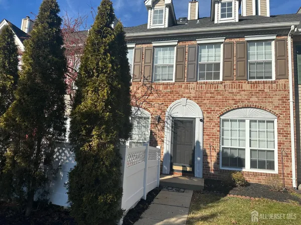 front view of a brick house with a small yard