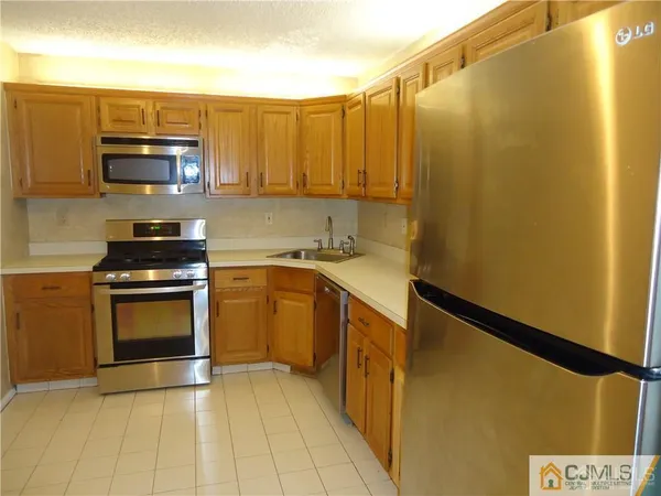 a kitchen with stainless steel appliances a stove a microwave a sink and cabinets