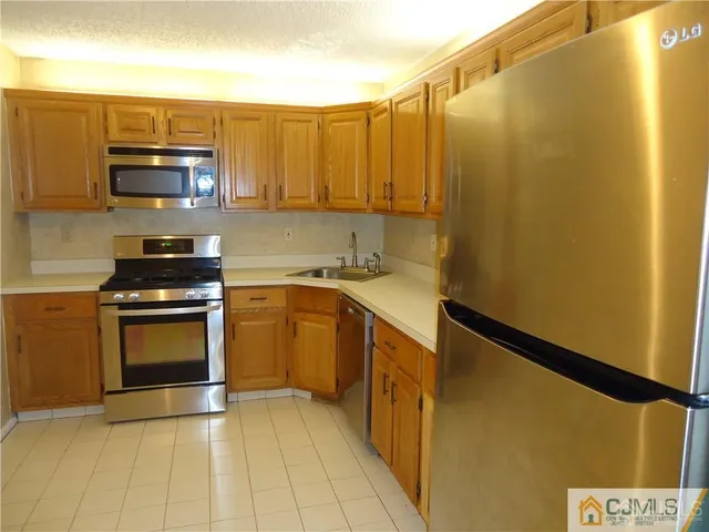 a kitchen with stainless steel appliances a stove a microwave a sink and cabinets