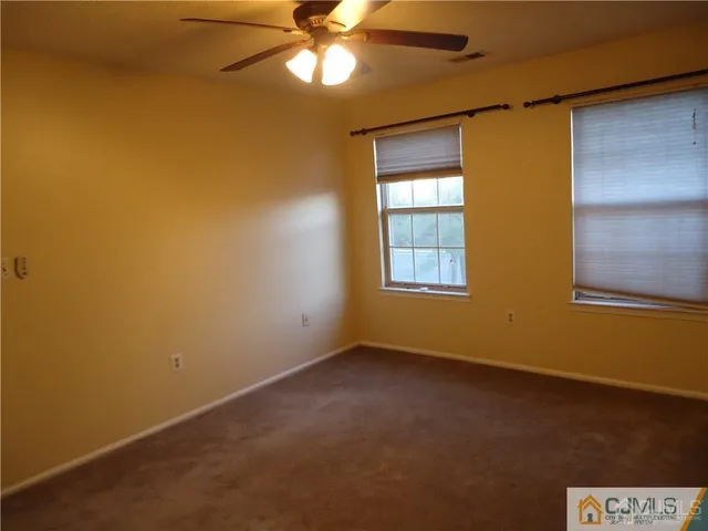 an empty room with a window and a fan
