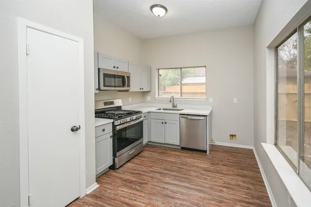 a kitchen with a stove a sink and a window