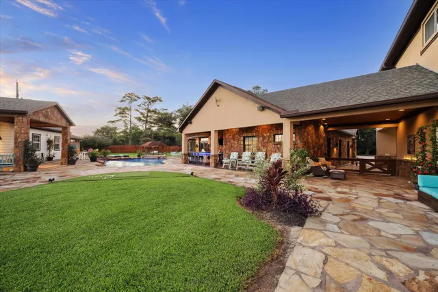 a view of a house with a big yard and large trees