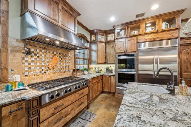 a kitchen with stainless steel appliances granite countertop a stove and a refrigerator