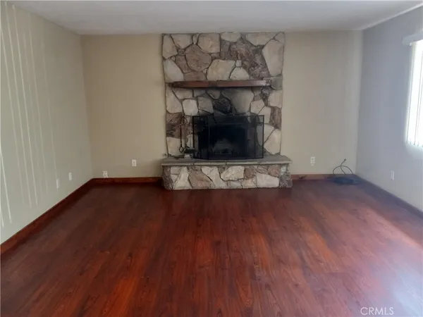 a living room with wooden floors and a fireplace