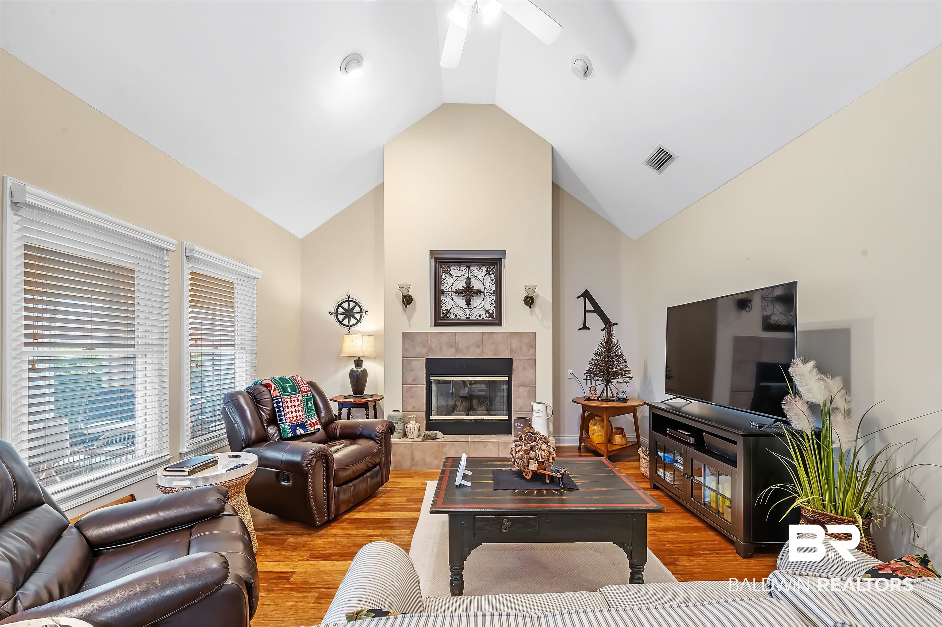 22726 Inverness Way Foley, AL 36535 - Photo 15 of 51 Living room featuring a tile fireplace, vaulted ceiling, light hardwood / wood-style flooring, and ceiling fan
