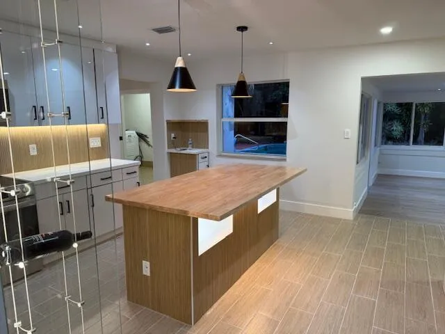 a kitchen with stainless steel appliances granite countertop a sink a stove and a wooden floors