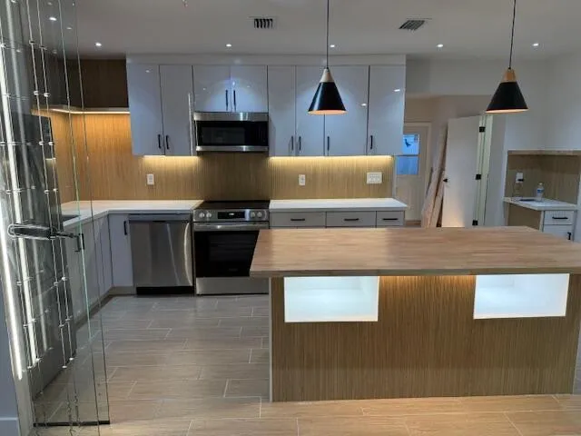 a kitchen with stainless steel appliances granite countertop a sink a stove and a refrigerator