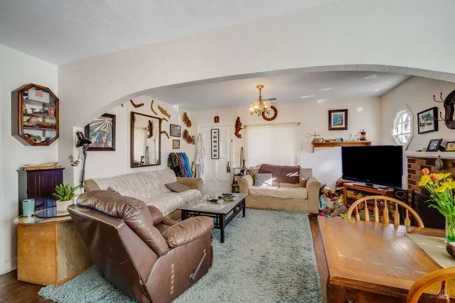 a living room with furniture kitchen view and a flat screen tv