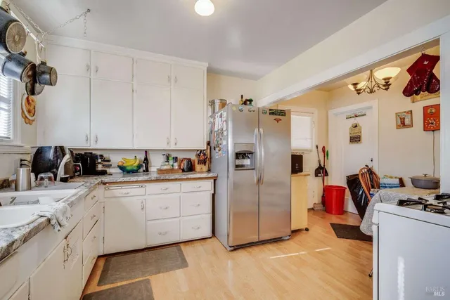 a kitchen with stainless steel appliances kitchen island granite countertop a refrigerator and a sink