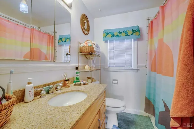 a bathroom with a sink vanity mirror and toilet