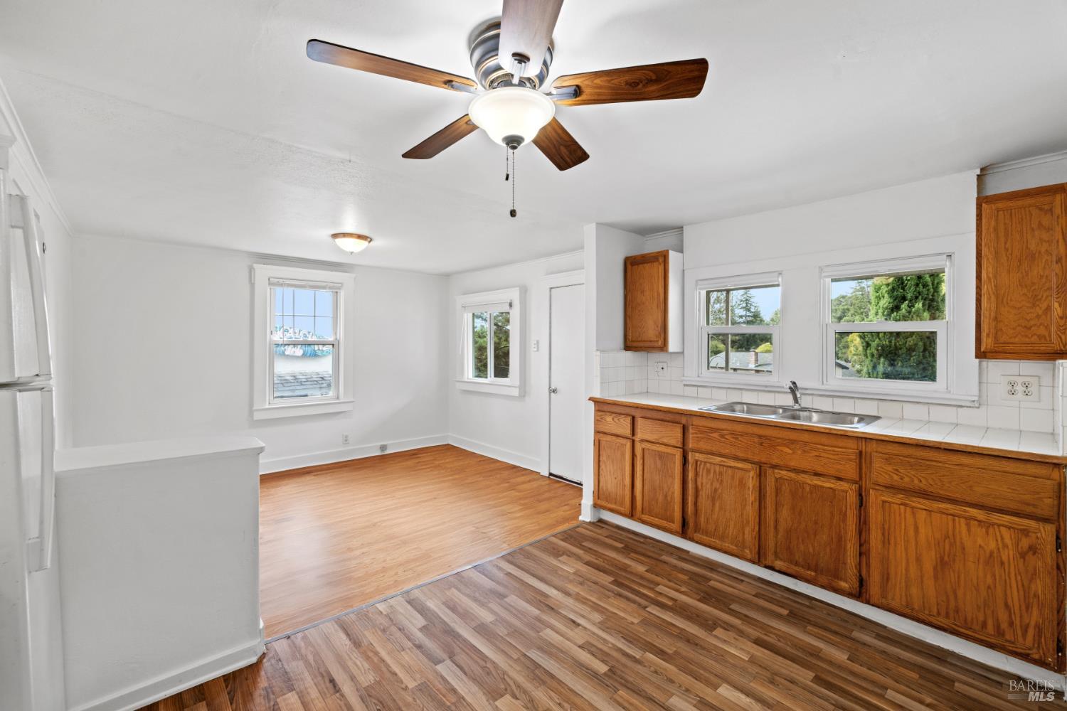 3160 Sunridge Drive Santa Rosa, CA 95404 - Photo 6 of 45 a view of a kitchen counter space with wooden floor and a ceiling fan