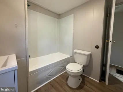 a white toilet sitting next to a bath tub