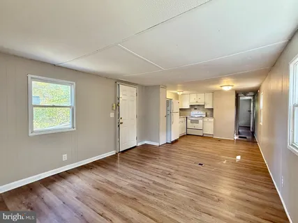 a view of empty room with wooden floor