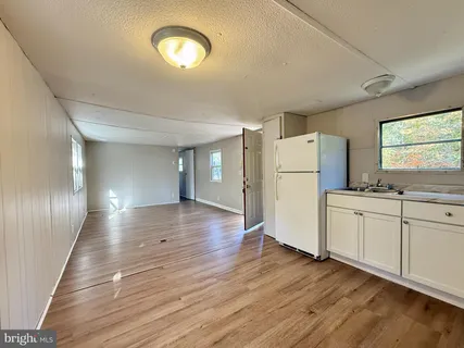 a view of a kitchen with wooden floor and electronic appliances