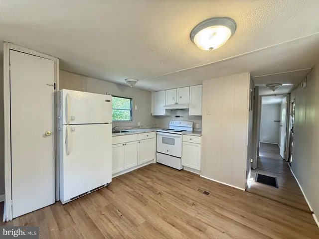 a kitchen with white cabinets and white appliances