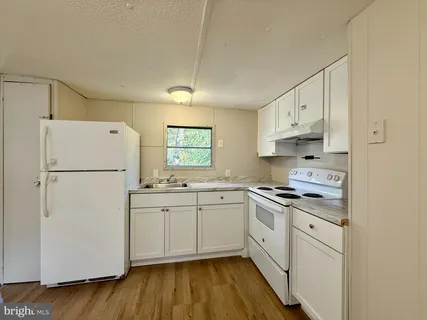 a kitchen with white cabinets and white appliances
