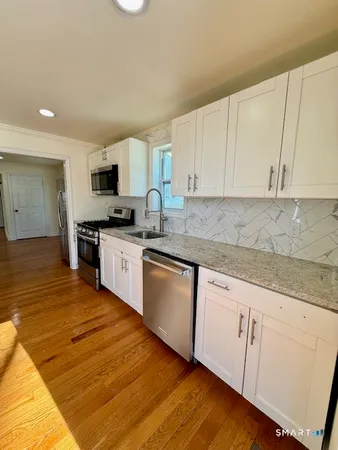 a kitchen with granite countertop white cabinets and white appliances