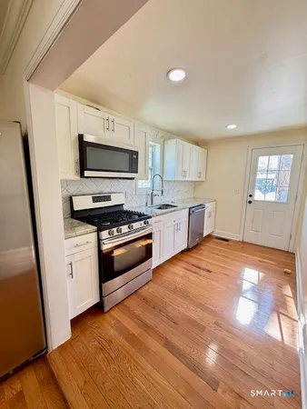 a kitchen with stainless steel appliances and a wooden floor