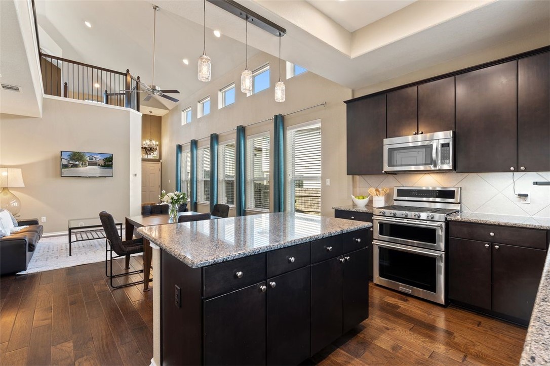720 Padron Lane, Unit 69 Austin, TX 78748 - Photo 1 of 1 a large kitchen with stainless steel appliances granite countertop a stove and a view of living room
