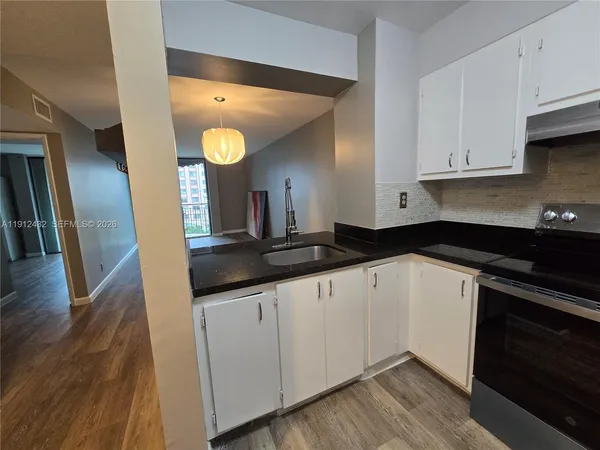 a kitchen with granite countertop a sink and cabinets