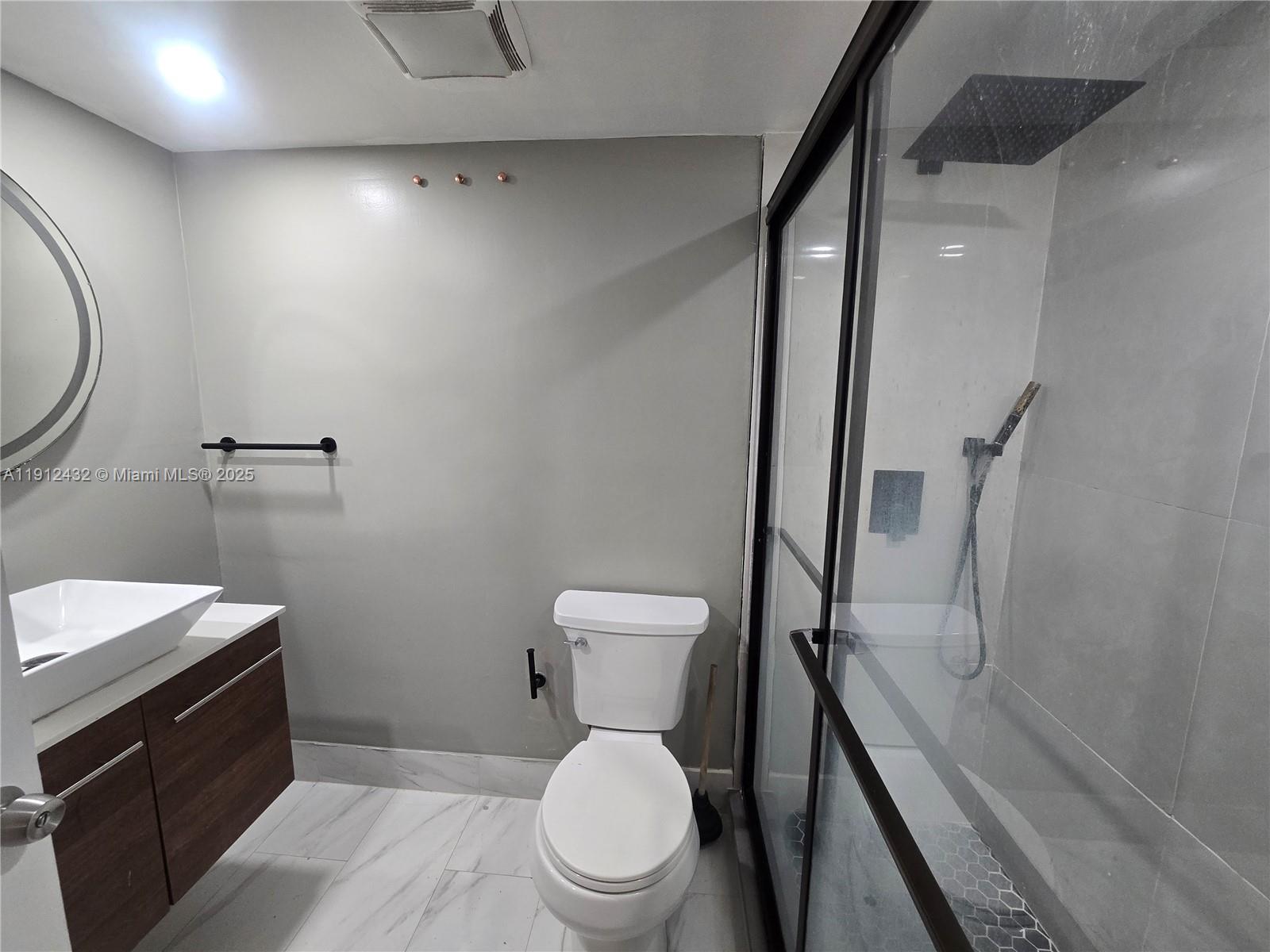 546 Southwest 1st Street, Unit 612 Miami, FL 33130 - Photo 10 of 20 a bathroom with a toilet a sink and wooden floor