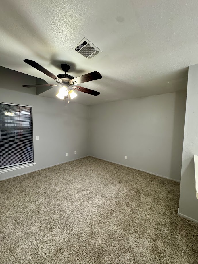 1305 West Villa Maria Road, Unit C107 Bryan, TX 77801 - Photo 11 of 19 Spare room with light carpet, a textured ceiling, and a ceiling fan