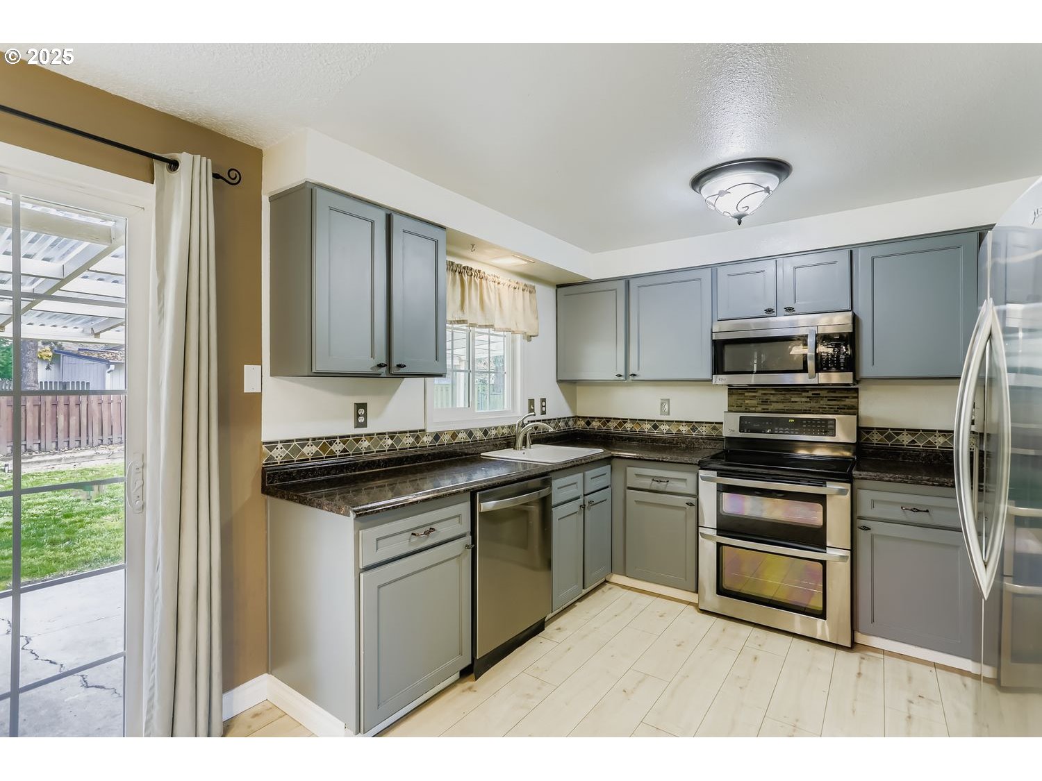 120 Northwest Giese Avenue Gresham, OR 97030 - Photo 5 of 17 a kitchen with stainless steel appliances granite countertop a stove sink and cabinets