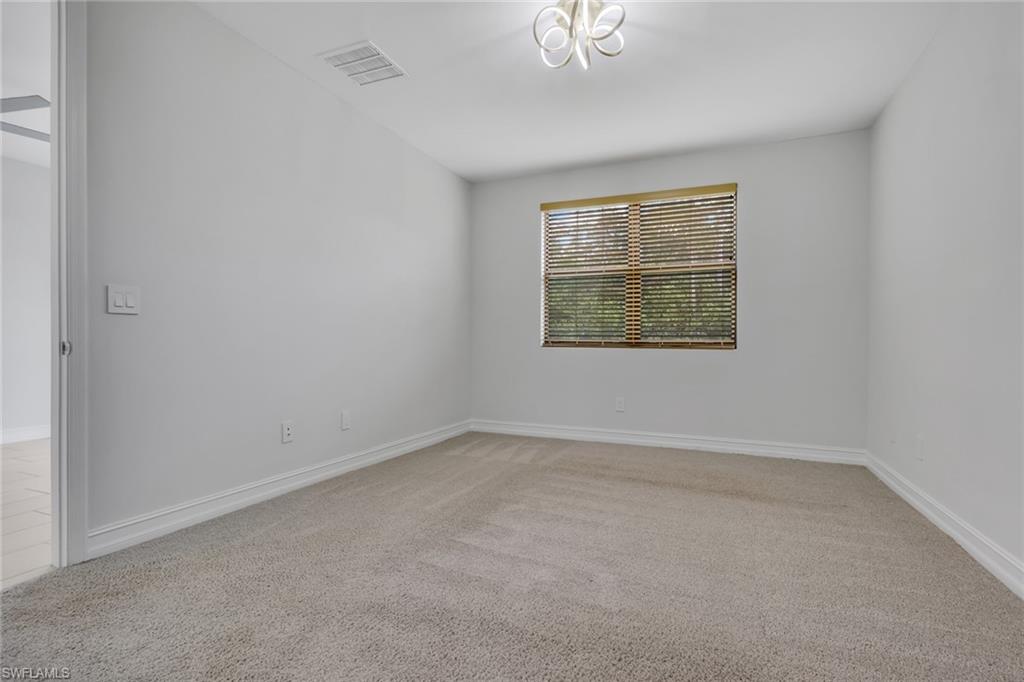 7501 Carnegie Way Naples, FL 34119 - Photo 19 of 37 Spare room with light carpet and baseboards