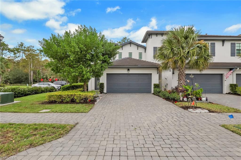 7501 Carnegie Way Naples, FL 34119 - Photo 2 of 37 View of front facade featuring decorative driveway, a garage, stucco siding, a tiled roof, and a front yard