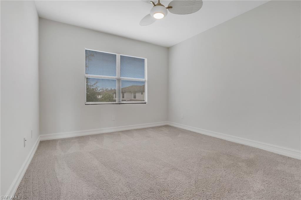7501 Carnegie Way Naples, FL 34119 - Photo 28 of 37 Carpeted spare room with baseboards and ceiling fan