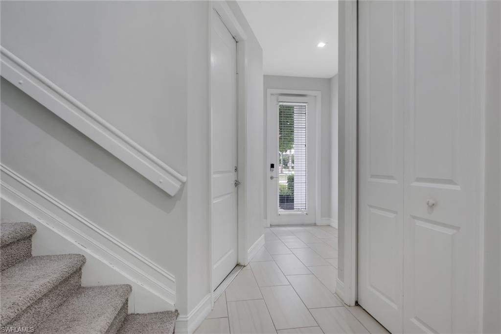 7501 Carnegie Way Naples, FL 34119 - Photo 3 of 37 Foyer entrance featuring stairway and light tile patterned flooring
