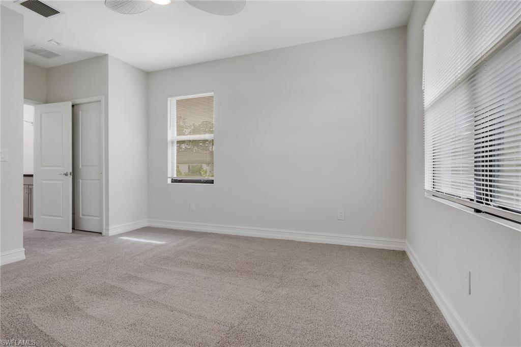 7501 Carnegie Way Naples, FL 34119 - Photo 34 of 37 Unfurnished bedroom featuring light colored carpet, ceiling fan, and a closet