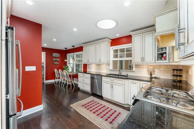 a kitchen with stainless steel appliances granite countertop a stove a sink dishwasher and a dining table with granite countertops