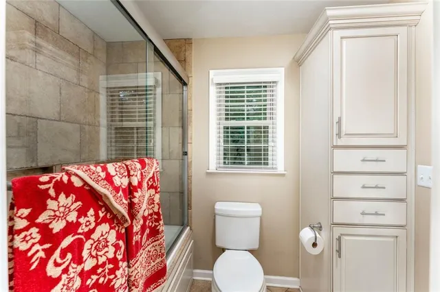 a bathroom with a toilet and shower curtain