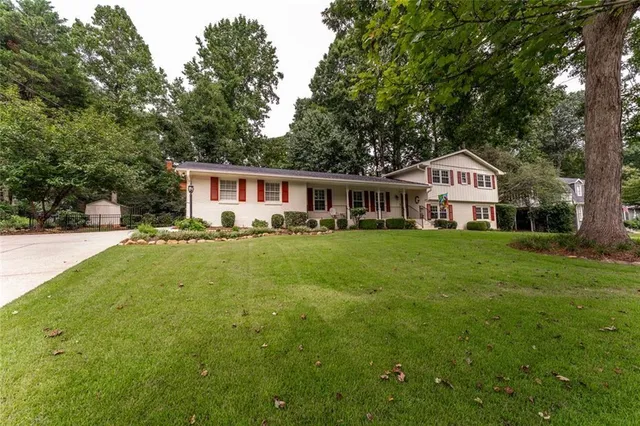 a front view of a house with yard and green space