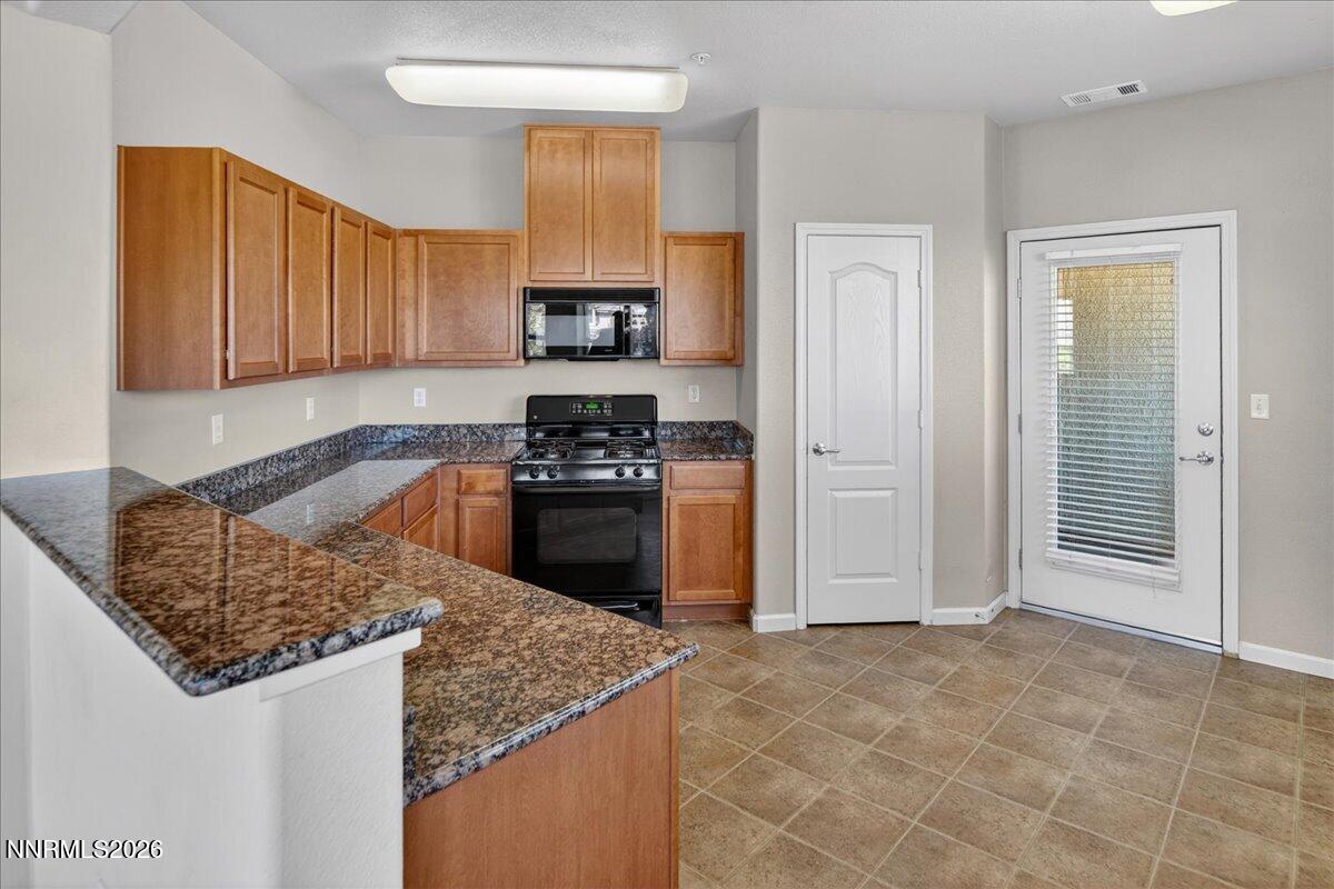 17000 Wedge Parkway, Unit 1525 Reno, NV 89511 - Photo 15 of 42 a kitchen with stainless steel appliances granite countertop a sink stove and refrigerator