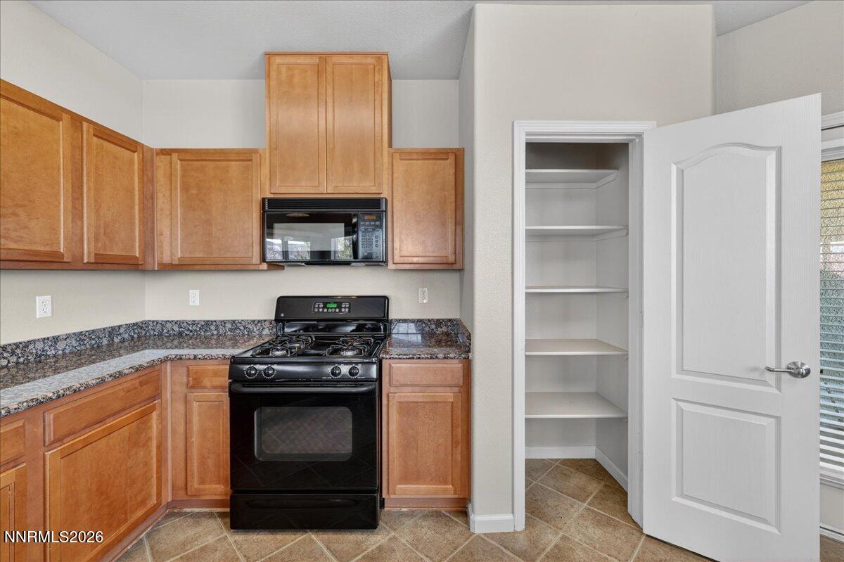 17000 Wedge Parkway, Unit 1525 Reno, NV 89511 - Photo 16 of 42 a kitchen with granite countertop white cabinets and stainless steel appliances