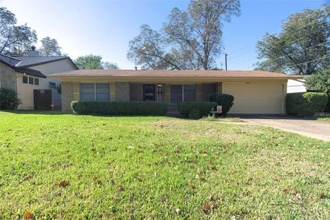 a view of a house with a yard and tree