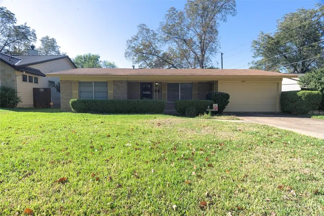 a view of a house with a yard and tree
