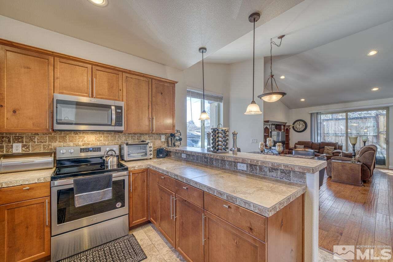 3677 Warren Way, Unit A Reno, NV 89509 - Photo 13 of 22 a view of a kitchen counter top space stove microwave and cabinets
