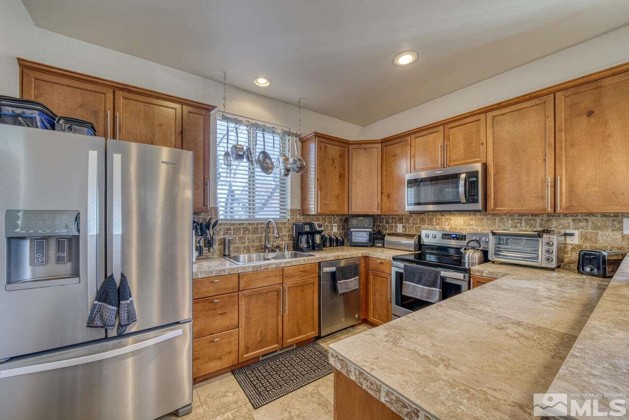3677 Warren Way, Unit A Reno, NV 89509 - Photo 14 of 22 a kitchen with stainless steel appliances granite countertop a refrigerator stove microwave and sink